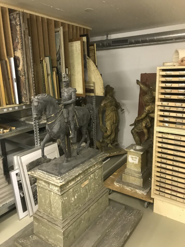 Museumsdepot: In der Mitte steht eine Skulptur von einem Mann auf einem Pferd.