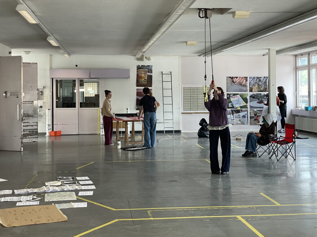 Junge Menschen beim Aufbau einer Ausstellung in einer grossen Halle.