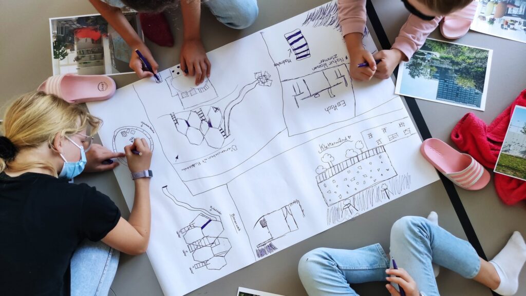 Eine Gruppe von Kindern zeichnet gemeinsam einen Raumplan.